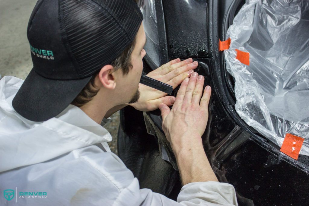 A man wearing a hat is working on a car