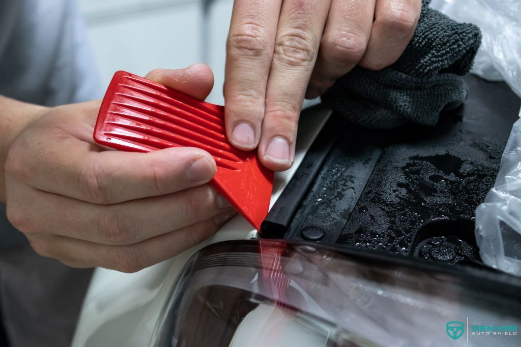 A close up of a person holding a red object in their hands.