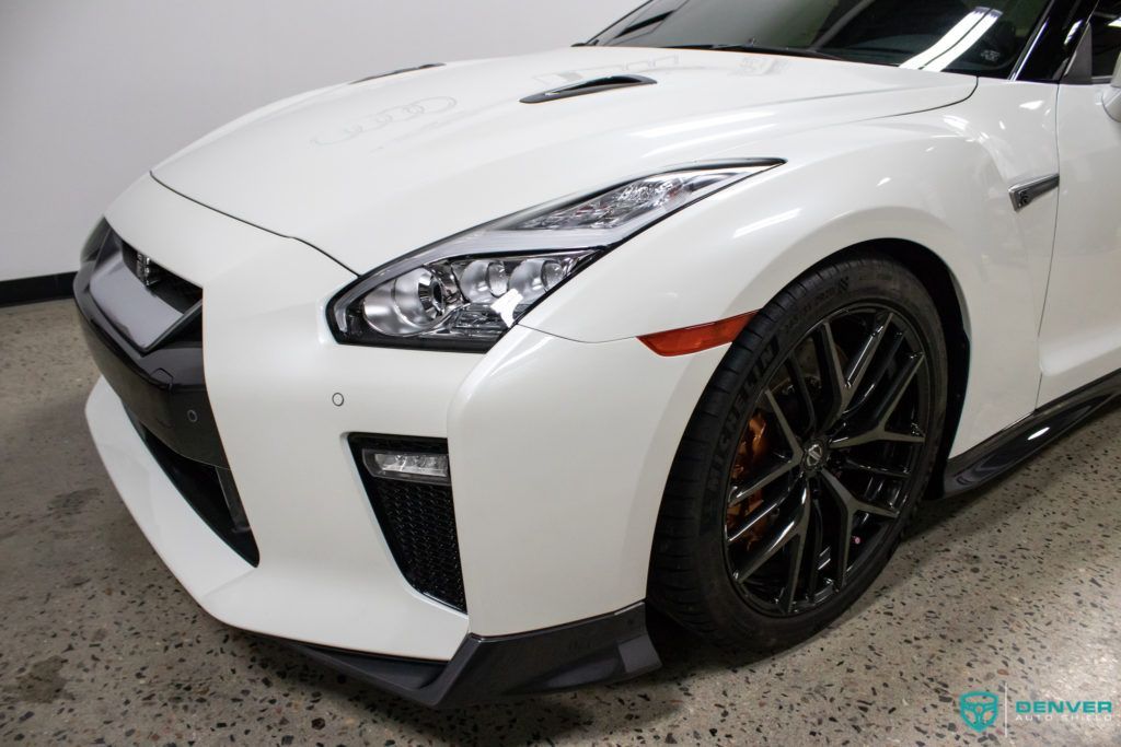 A white nissan gtr is parked in a garage.