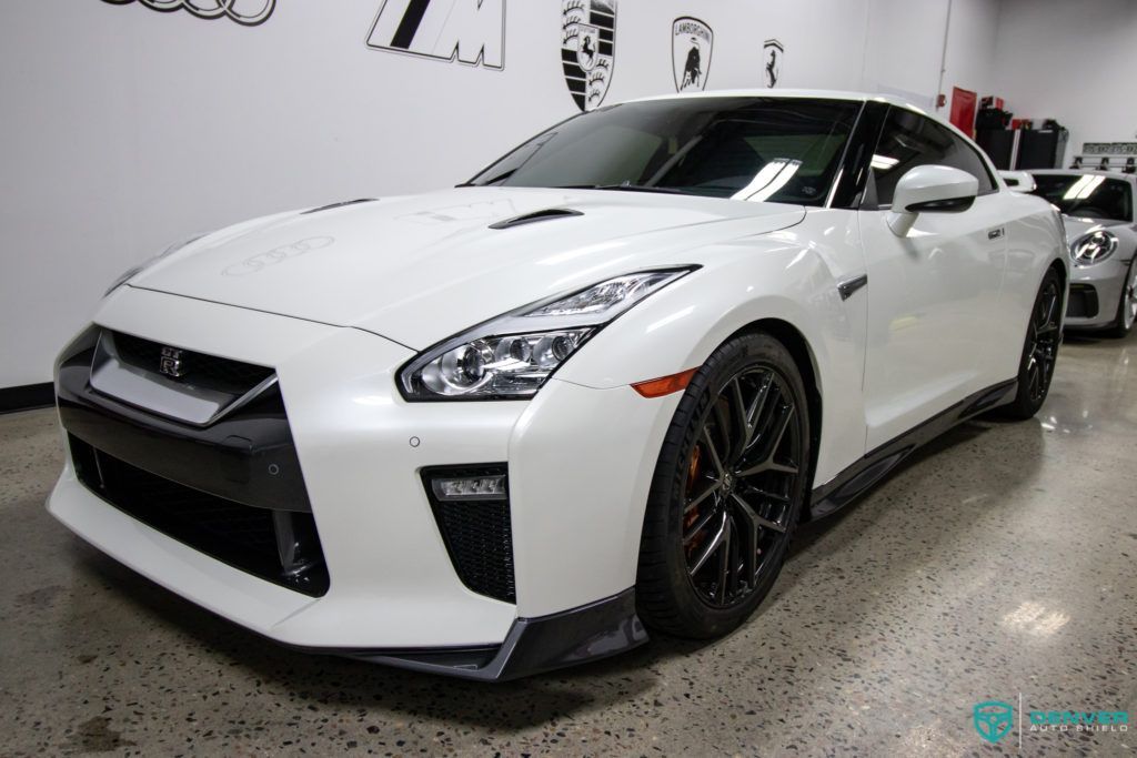 A white sports car is parked in a showroom.