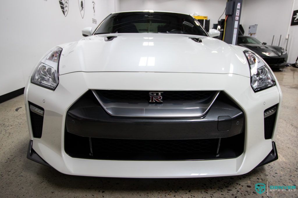 A white nissan gtr is parked in a garage