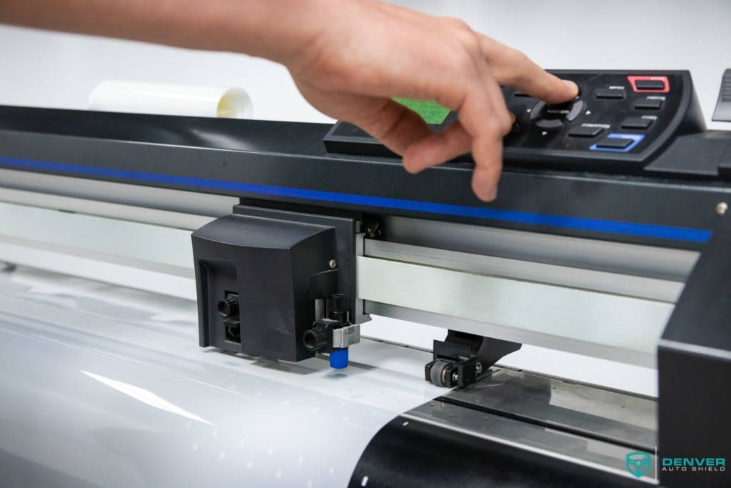 A person is using a cutting machine to cut a piece of paper.