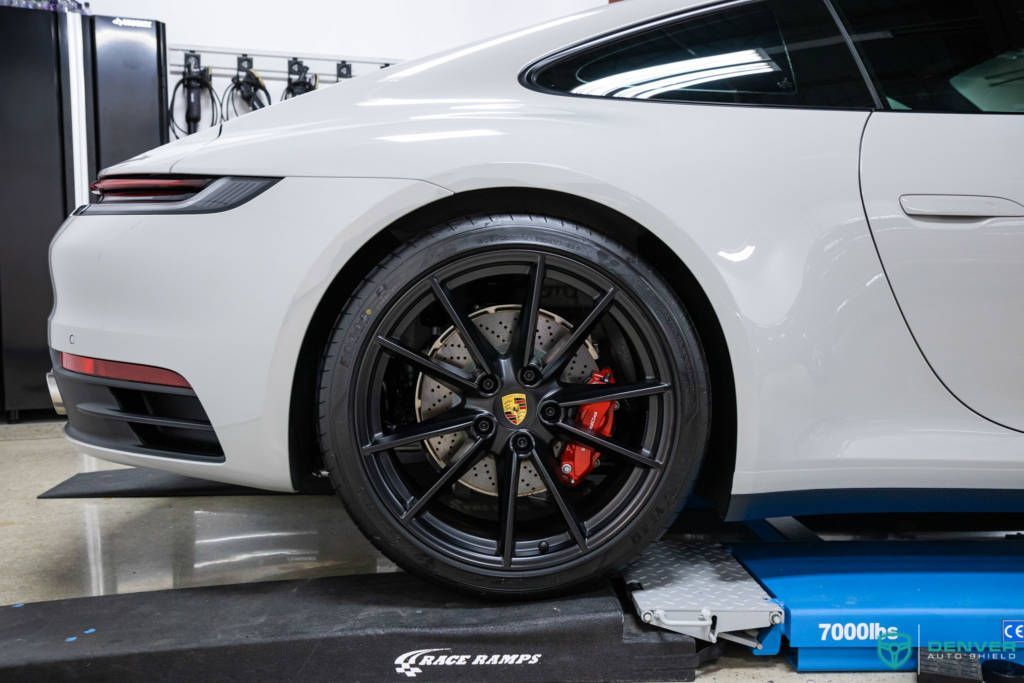 A white porsche 911 is sitting on top of a blue ramp.