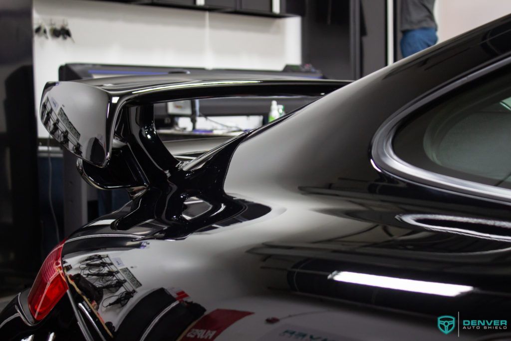 A black sports car is parked in a garage.