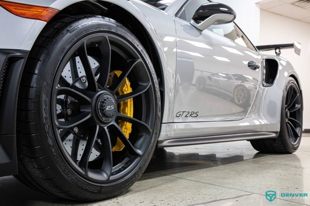 A silver porsche 911 gt3 rs is parked in a showroom.