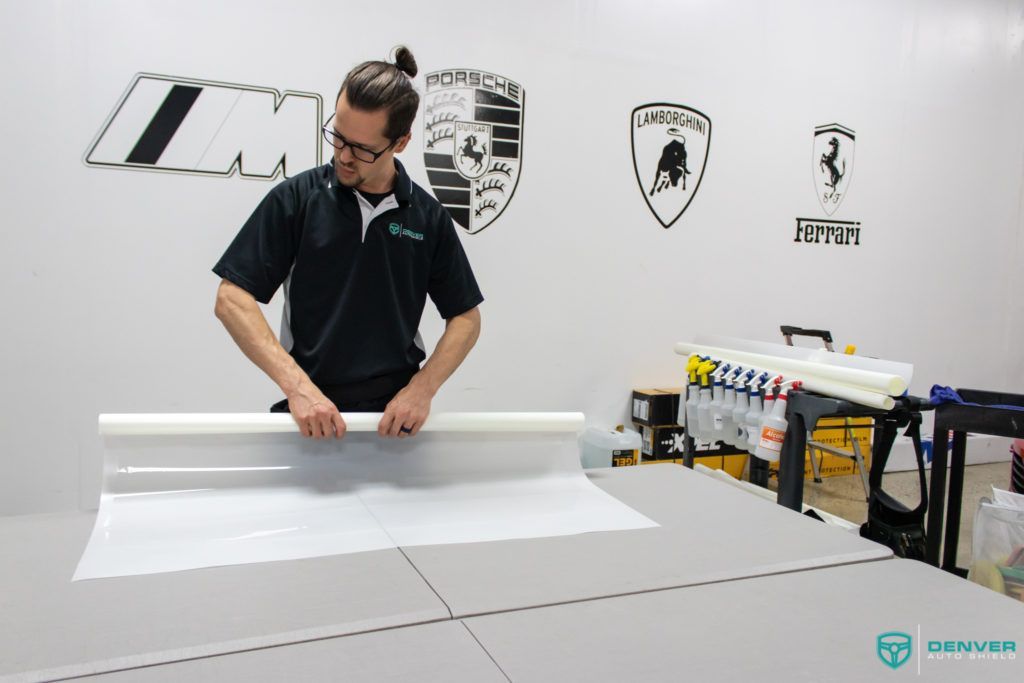 A man is cutting a piece of paper on a table.