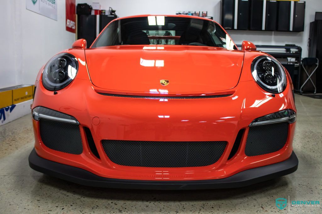 A red sports car is parked in a garage.