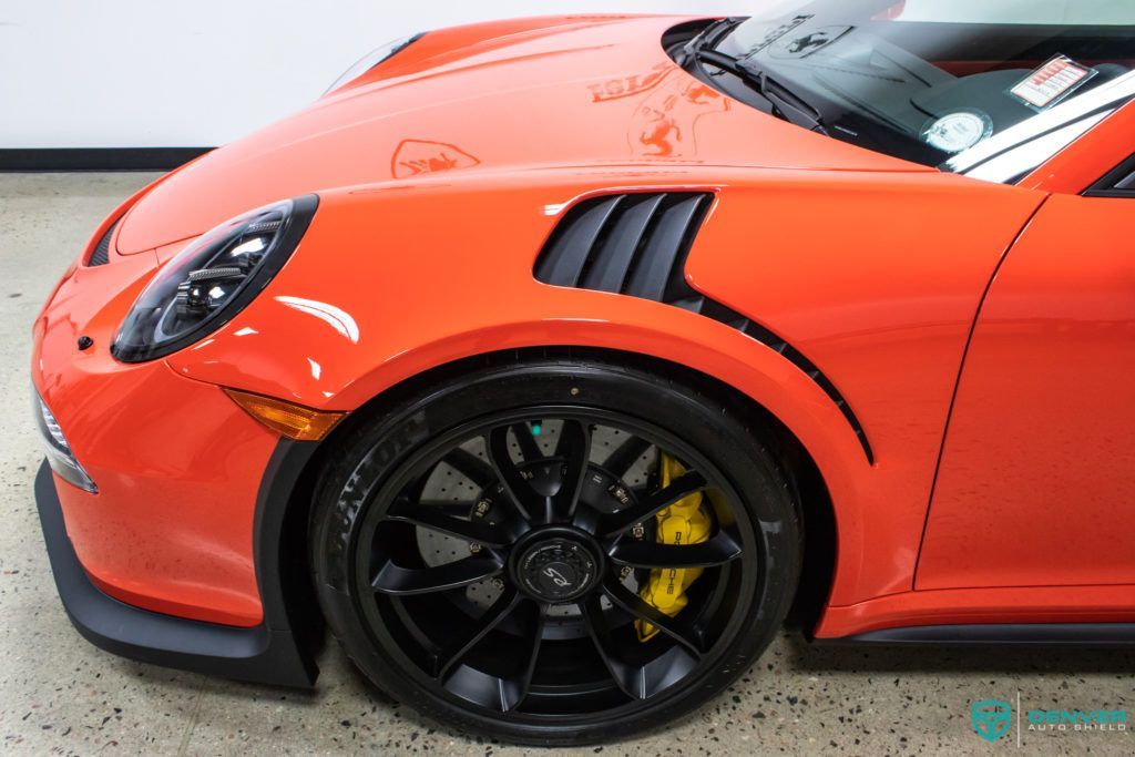 A red porsche 911 gt3 rs is parked in a garage.