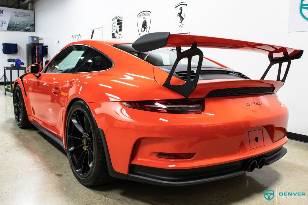 A red porsche 911 gt3 rs is parked in a garage.