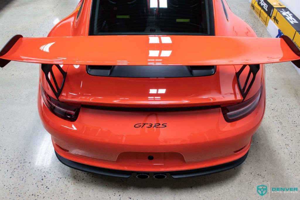 The rear end of an orange porsche 911 gt3 rs