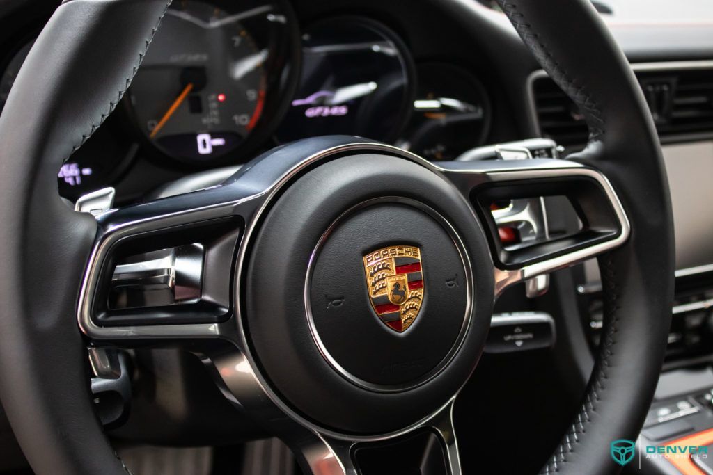 A close up of a porsche steering wheel