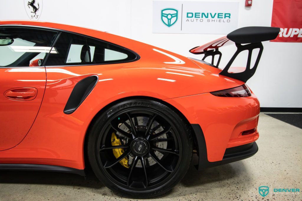 A red porsche 911 gt3 rs is parked in a garage.