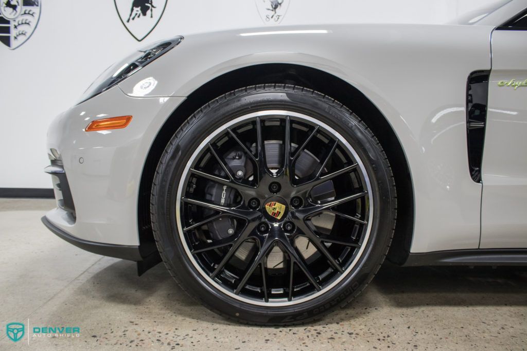 A silver porsche panamera turbo s is parked in a garage.