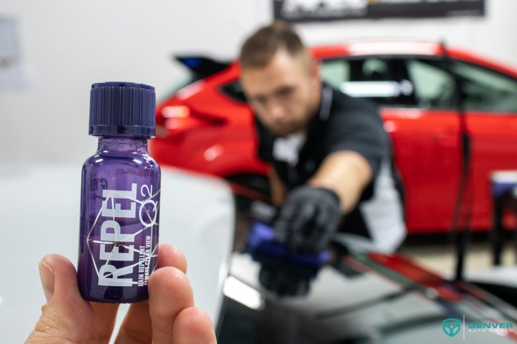 A person is holding a purple bottle with the word rebel on it.