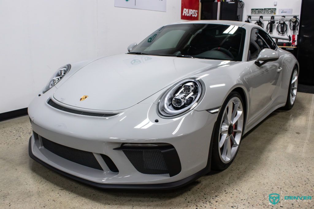 A white porsche 911 gt3 is parked in a garage.