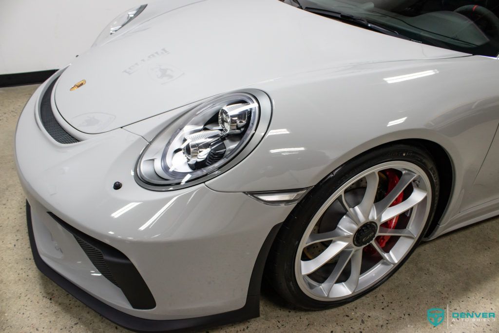 A white porsche 911 gt3 is parked in a garage.