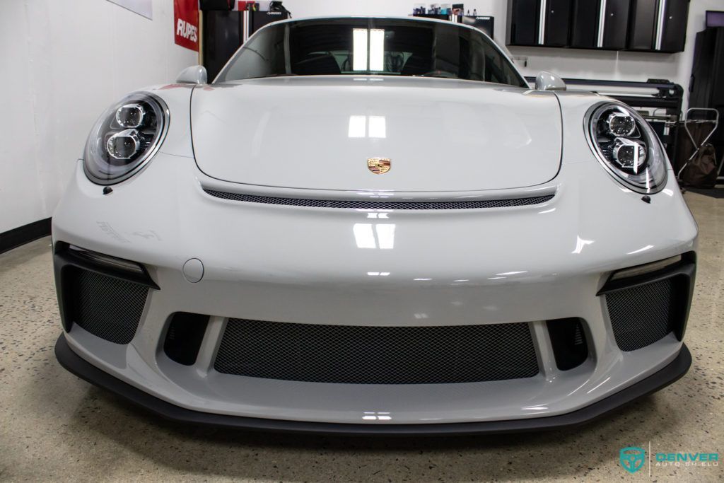 A white porsche 911 gt3 rs is parked in a garage.