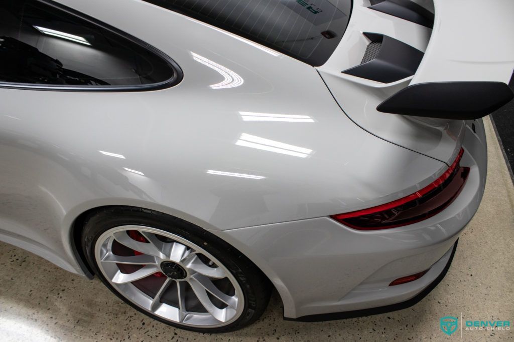 A white porsche 911 gt3 is parked in a garage.