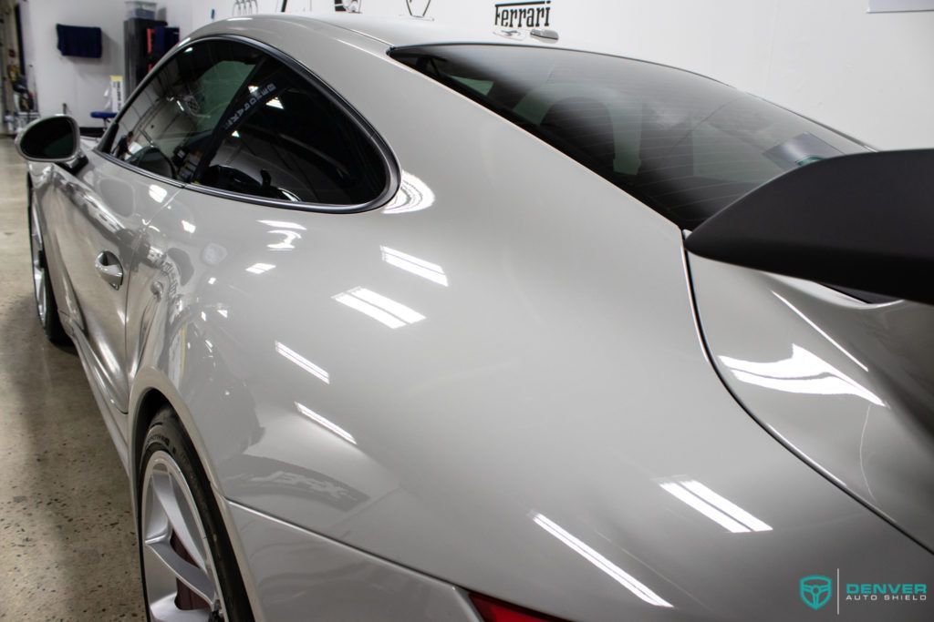 A silver sports car is parked in a garage.