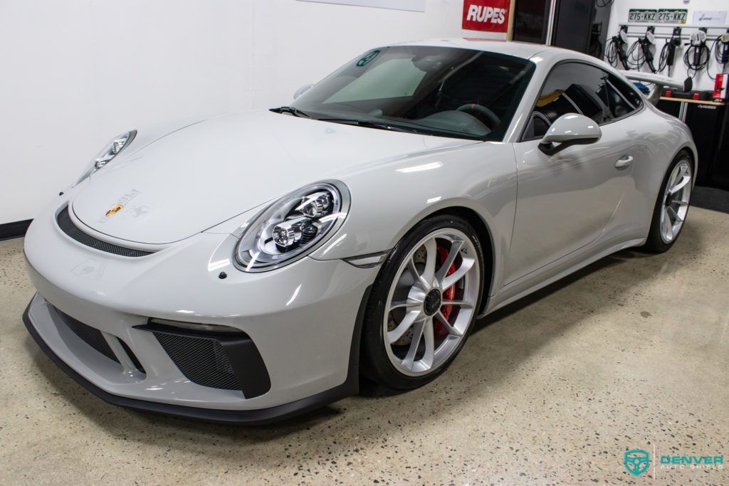 A white porsche 911 gt3 is parked in a garage.