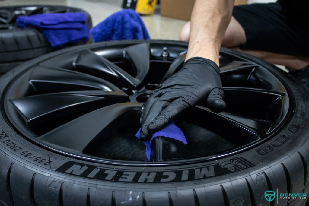 A person is cleaning a michelin tire with a cloth.