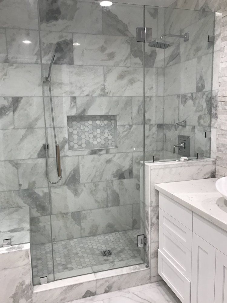 A bathroom with a walk in shower and a sink.