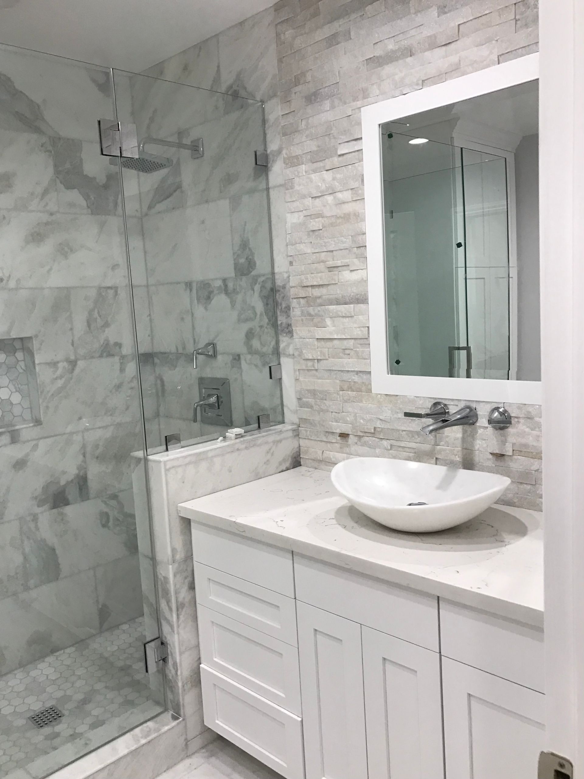 A bathroom with a sink , mirror and shower.