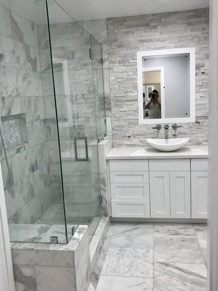 A bathroom with a walk in shower , sink , and mirror.