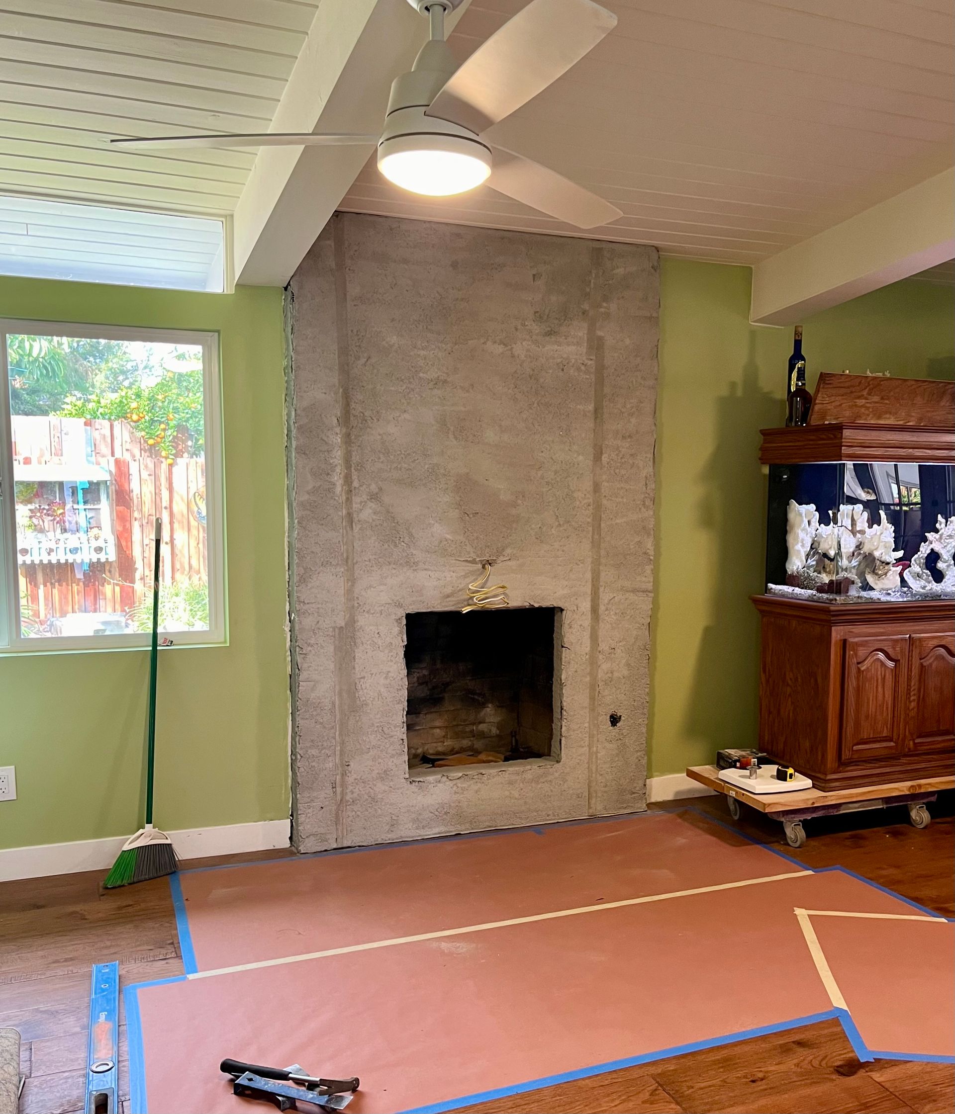 A living room with a fireplace and a ceiling fan