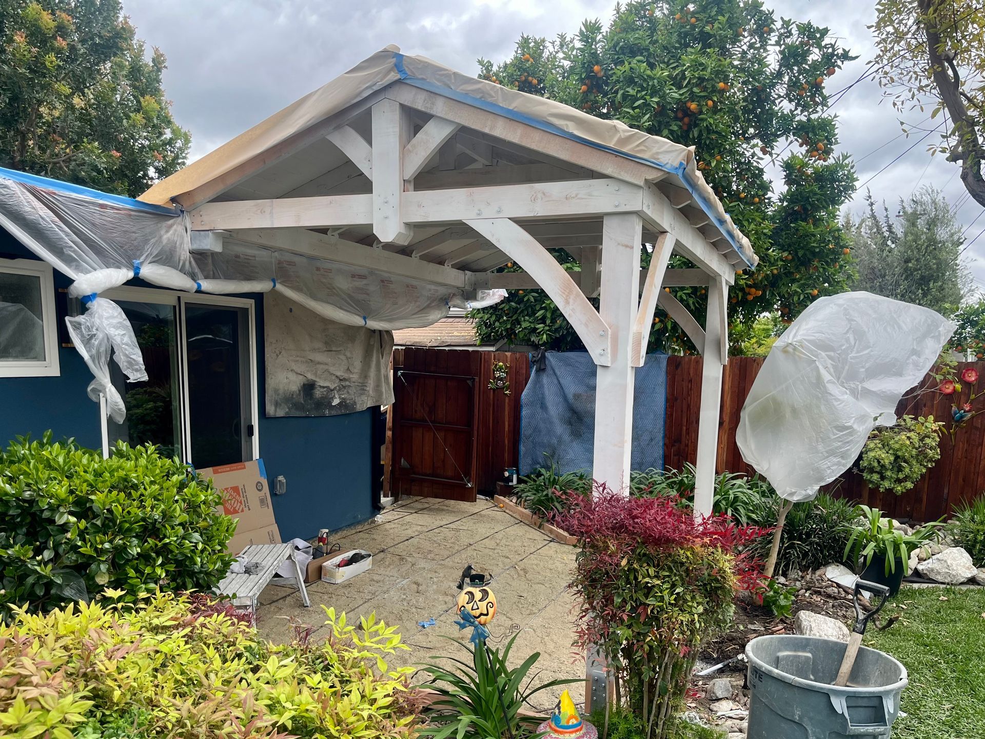 A blue house with a white roof is being painted.