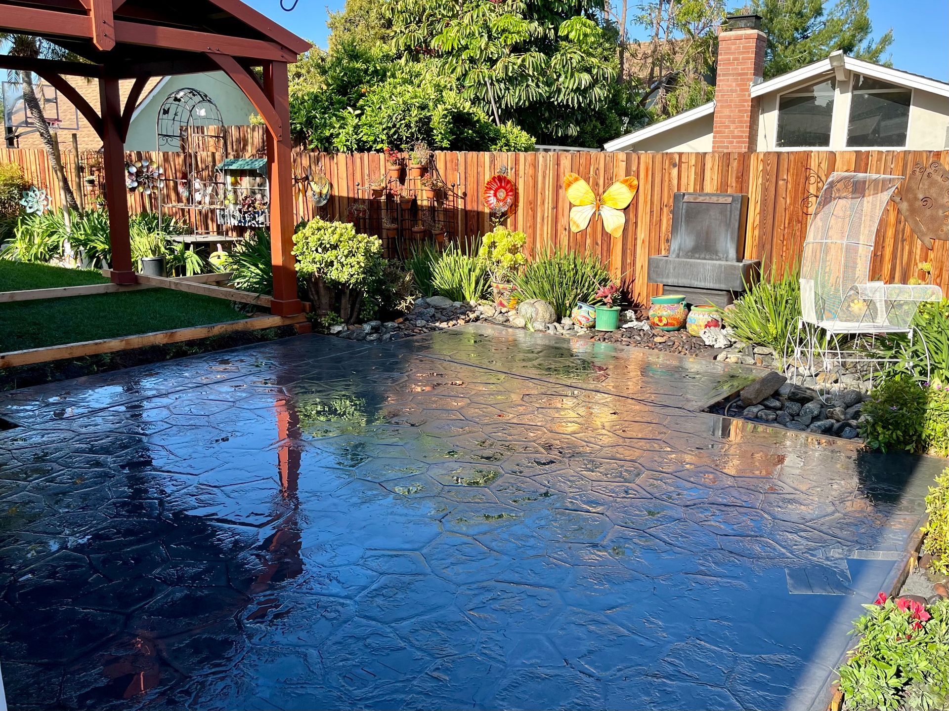 A backyard with a wooden fence and a gazebo.