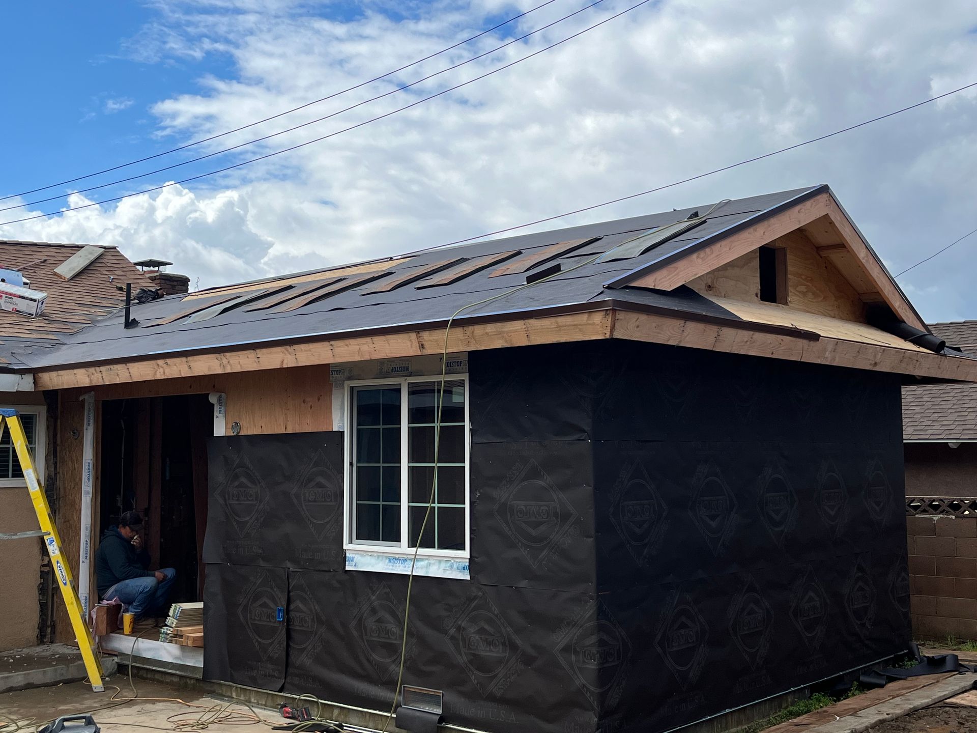 A small house is being built with a metal roof.
