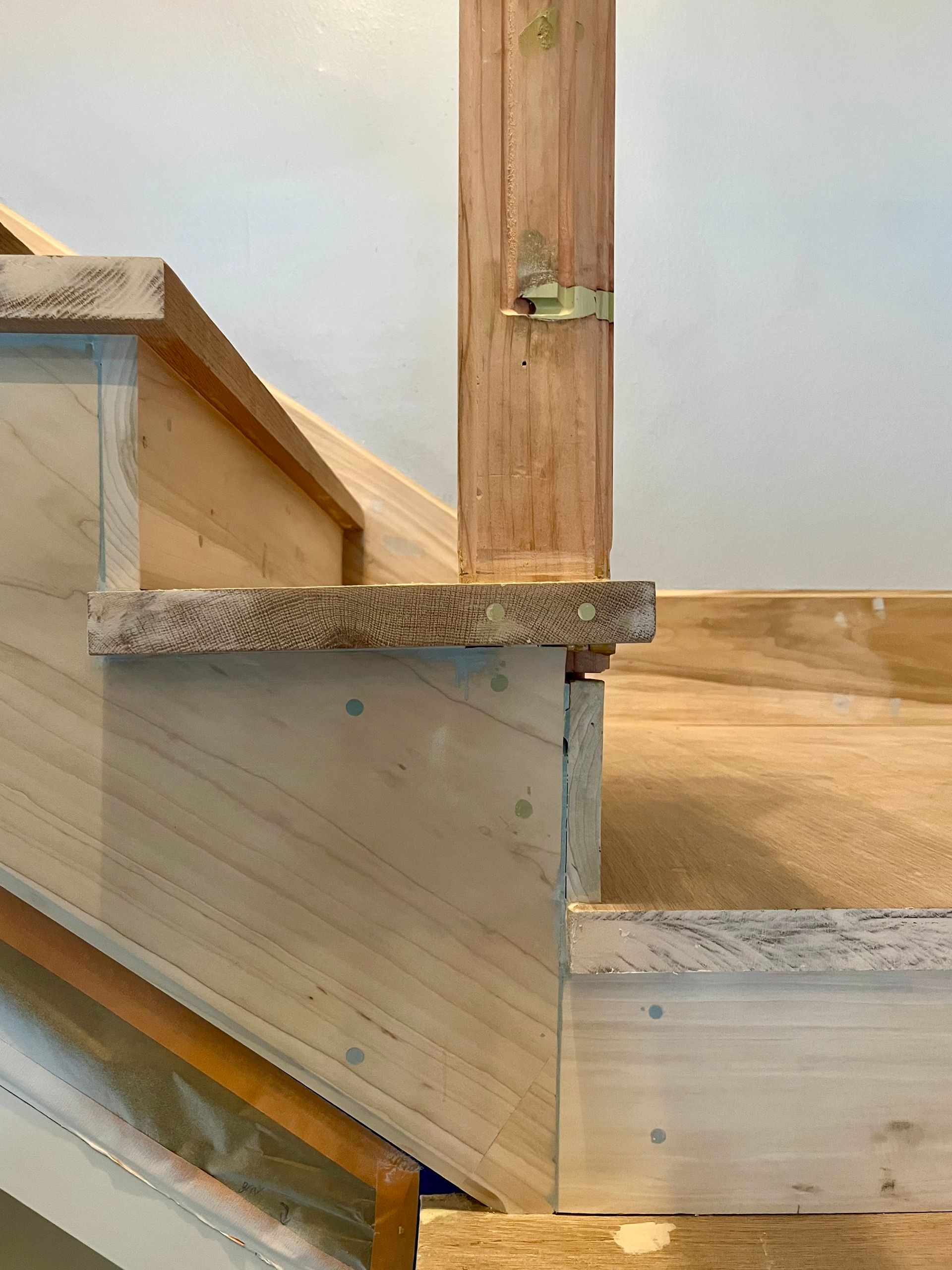 A wooden staircase is being built in a house.