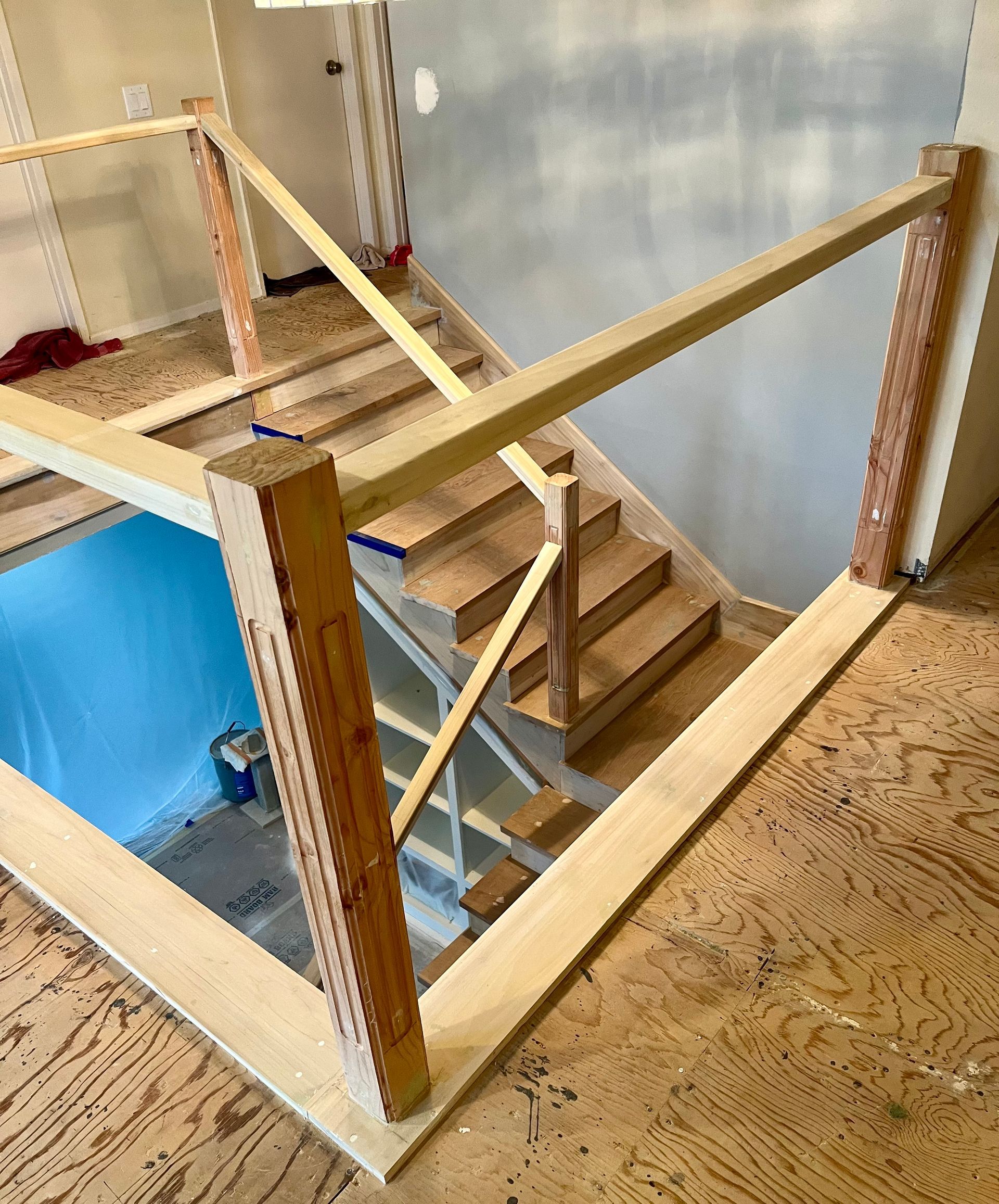 A wooden staircase is being built in a house.