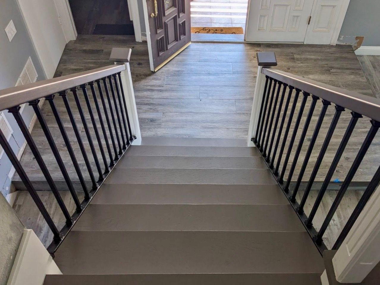 A staircase with a metal railing leading up to the second floor of a house.