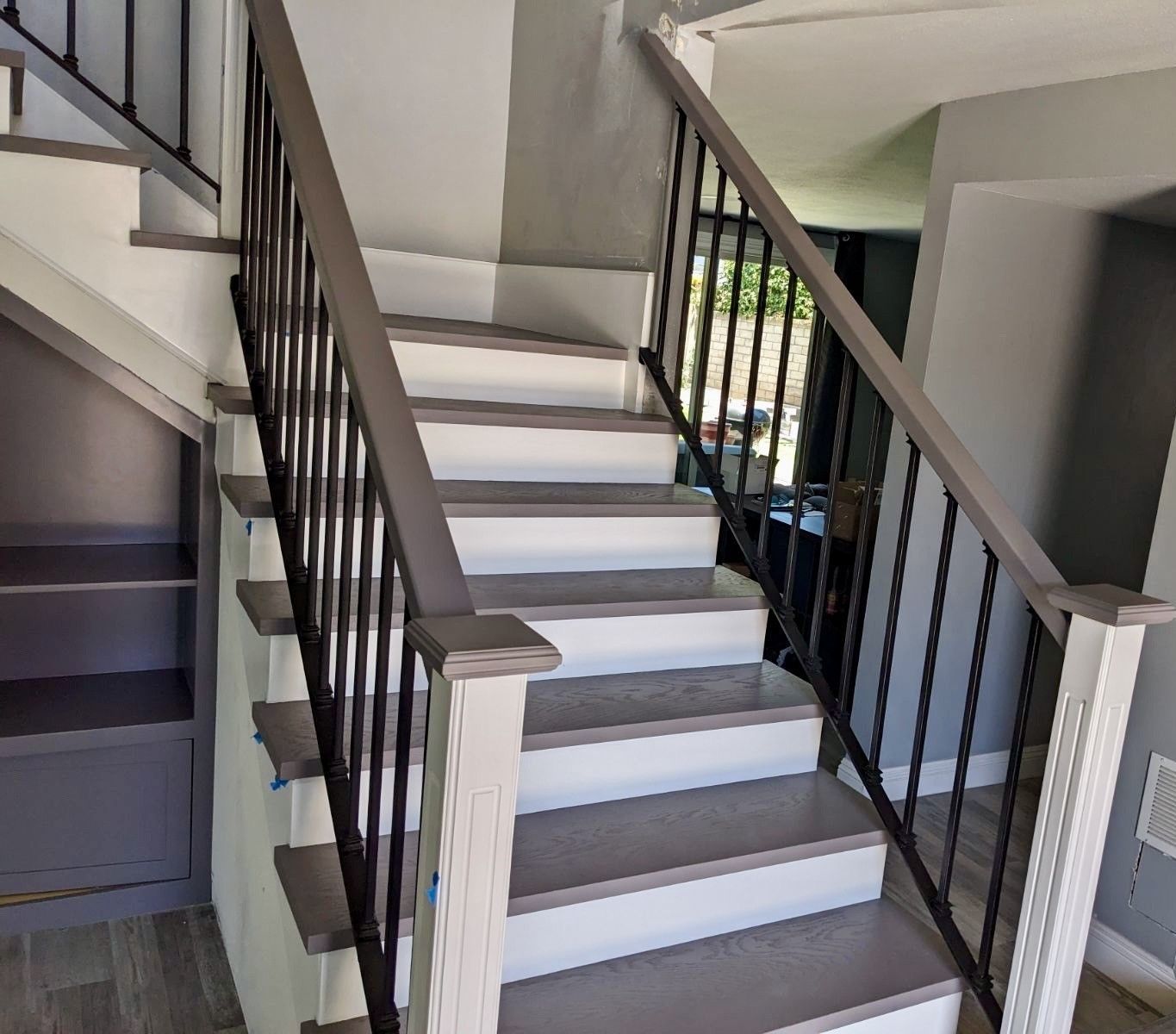 A staircase with white steps and a black railing in a house.