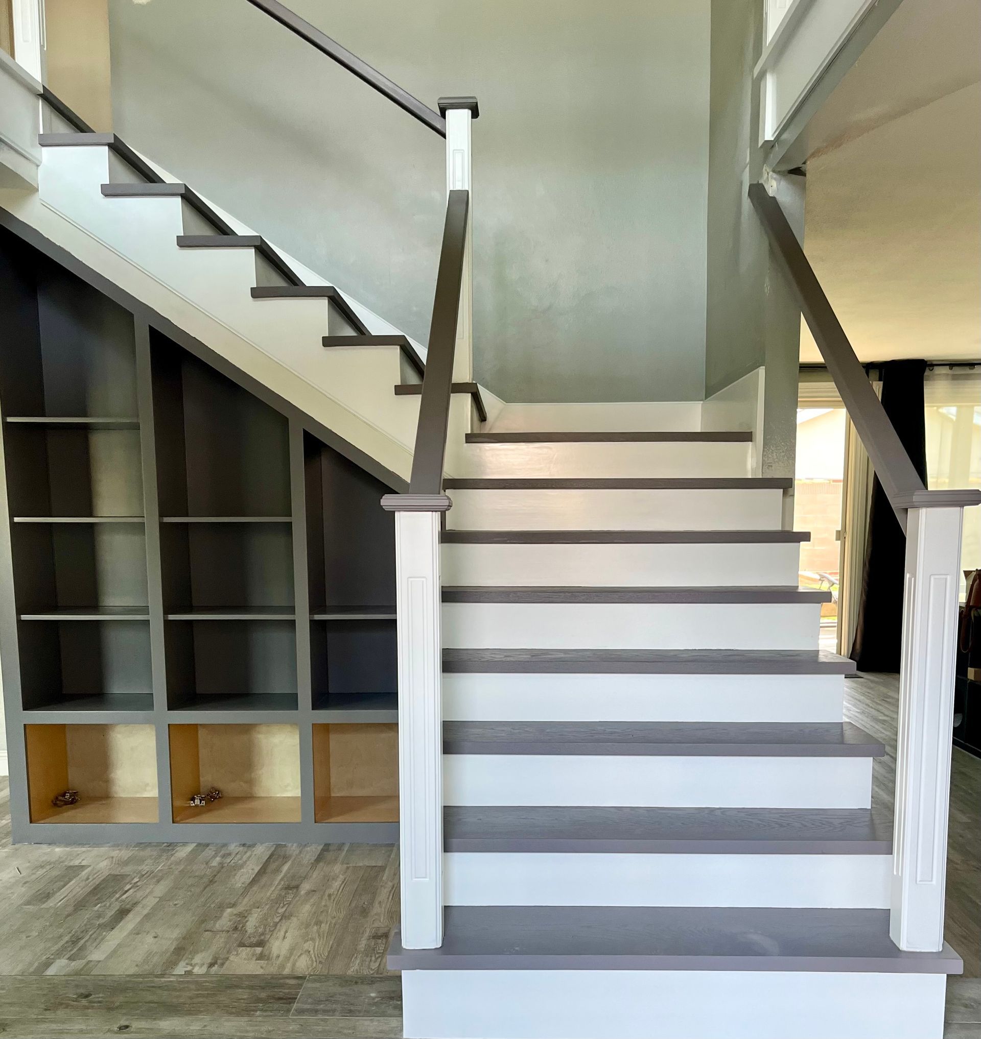 A white staircase with gray steps and a glass railing