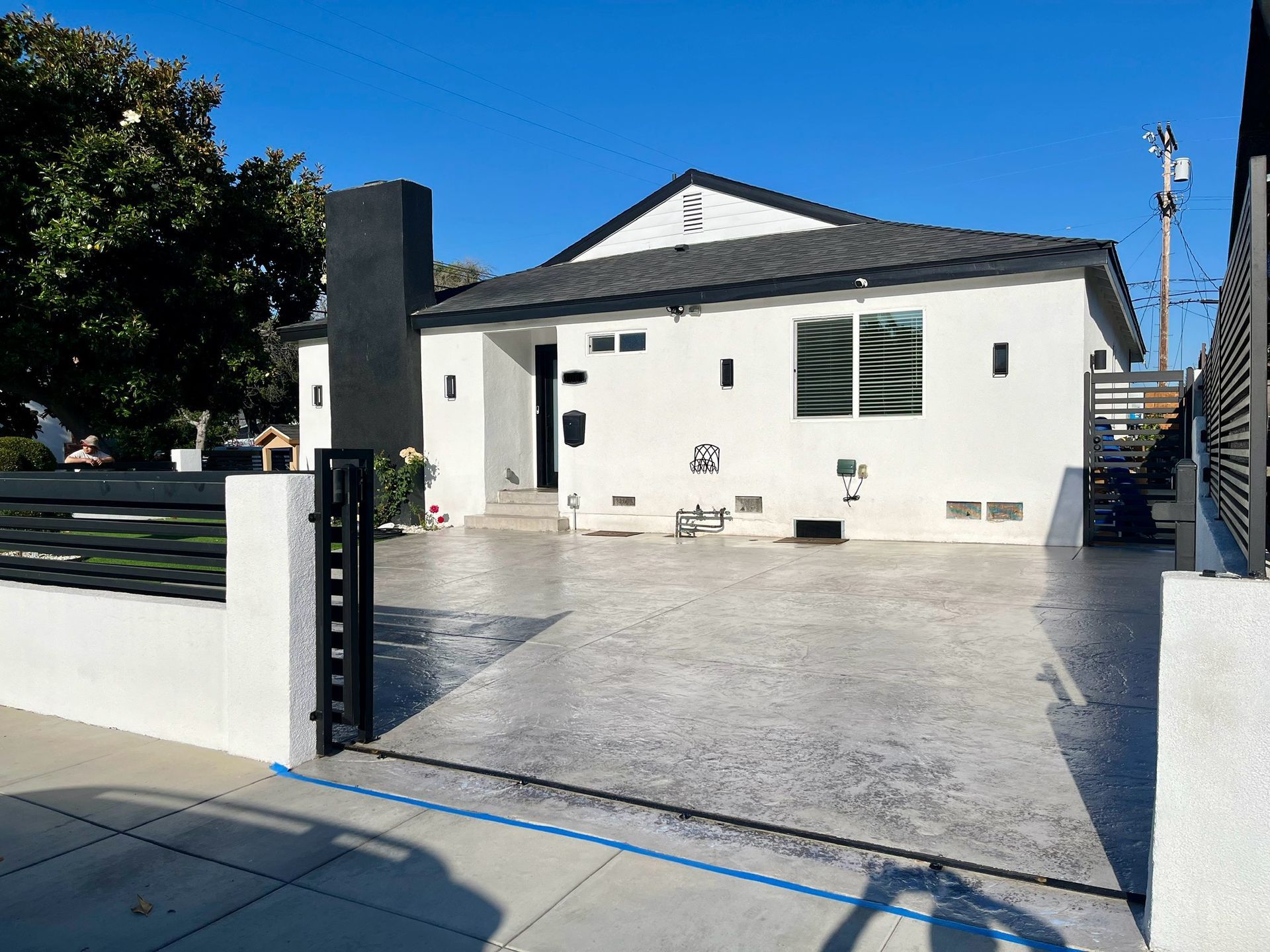 A white house with a black fence and a driveway