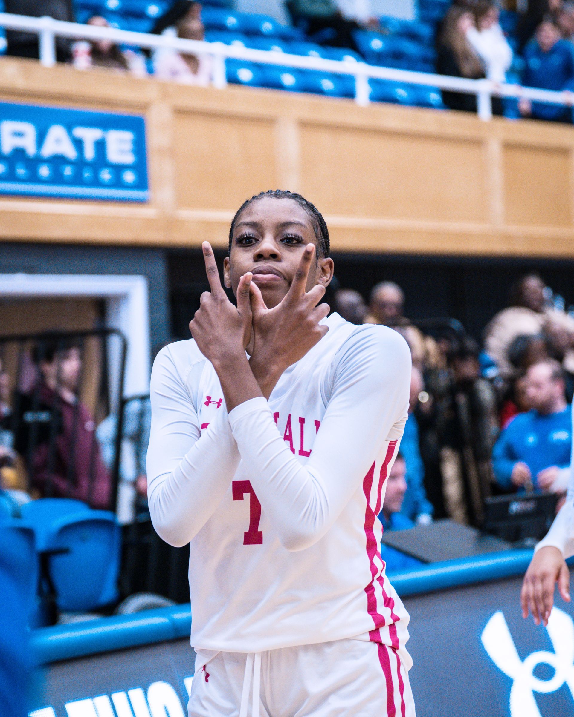 Basketball player in white uniform making a hand gesture on the court during a game
