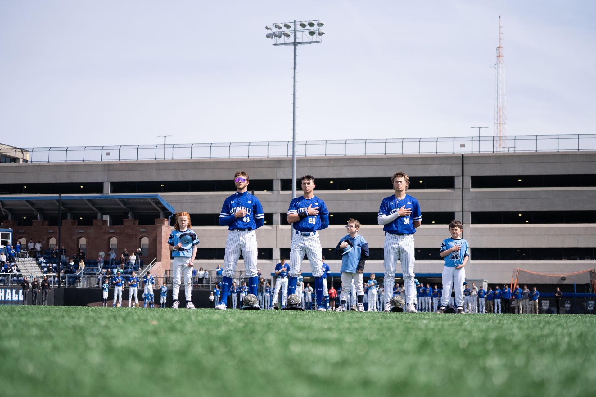 Baseball players in blue uniforms lined up on the field before a game