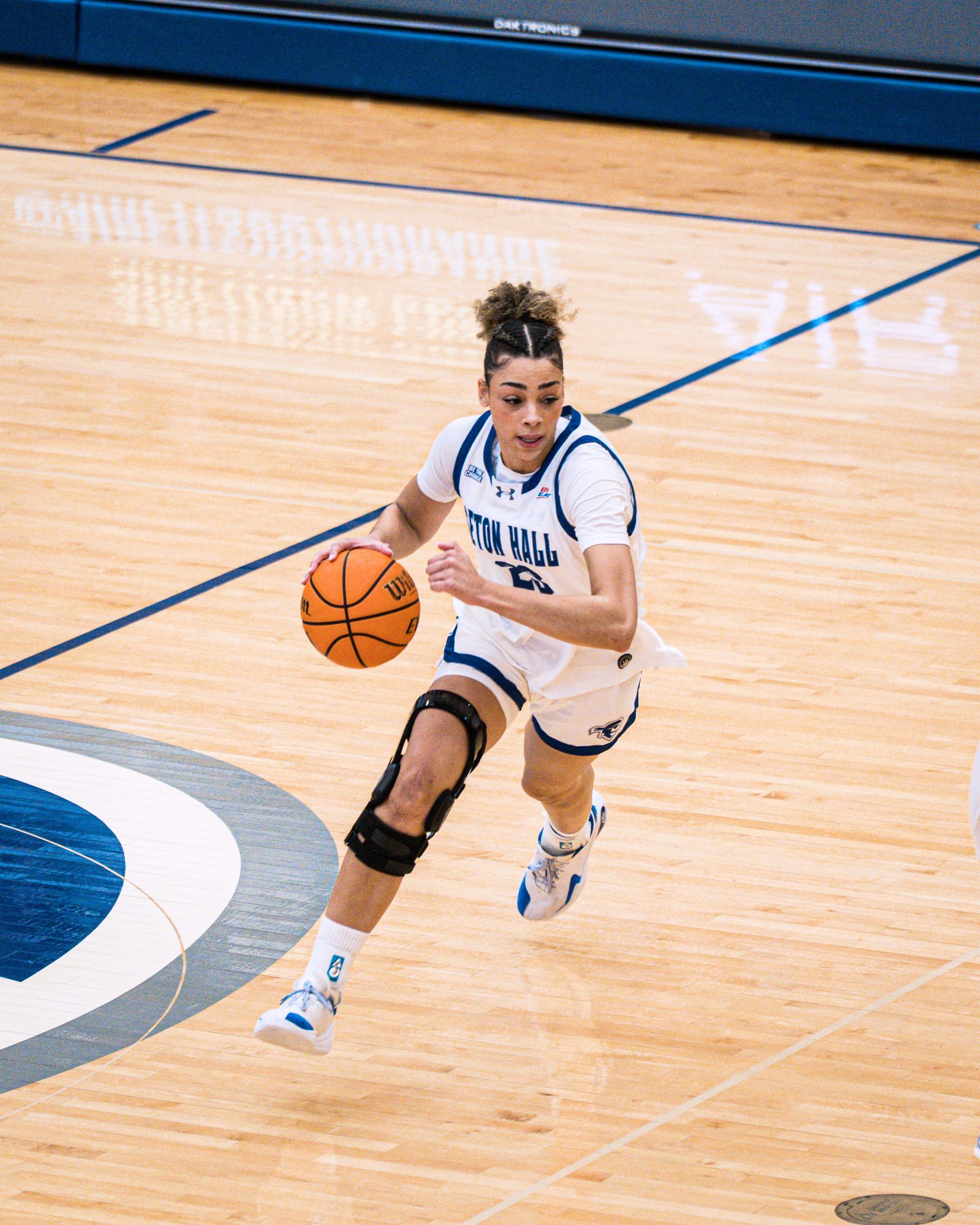 Basketball player in white dribbling on a court during a game