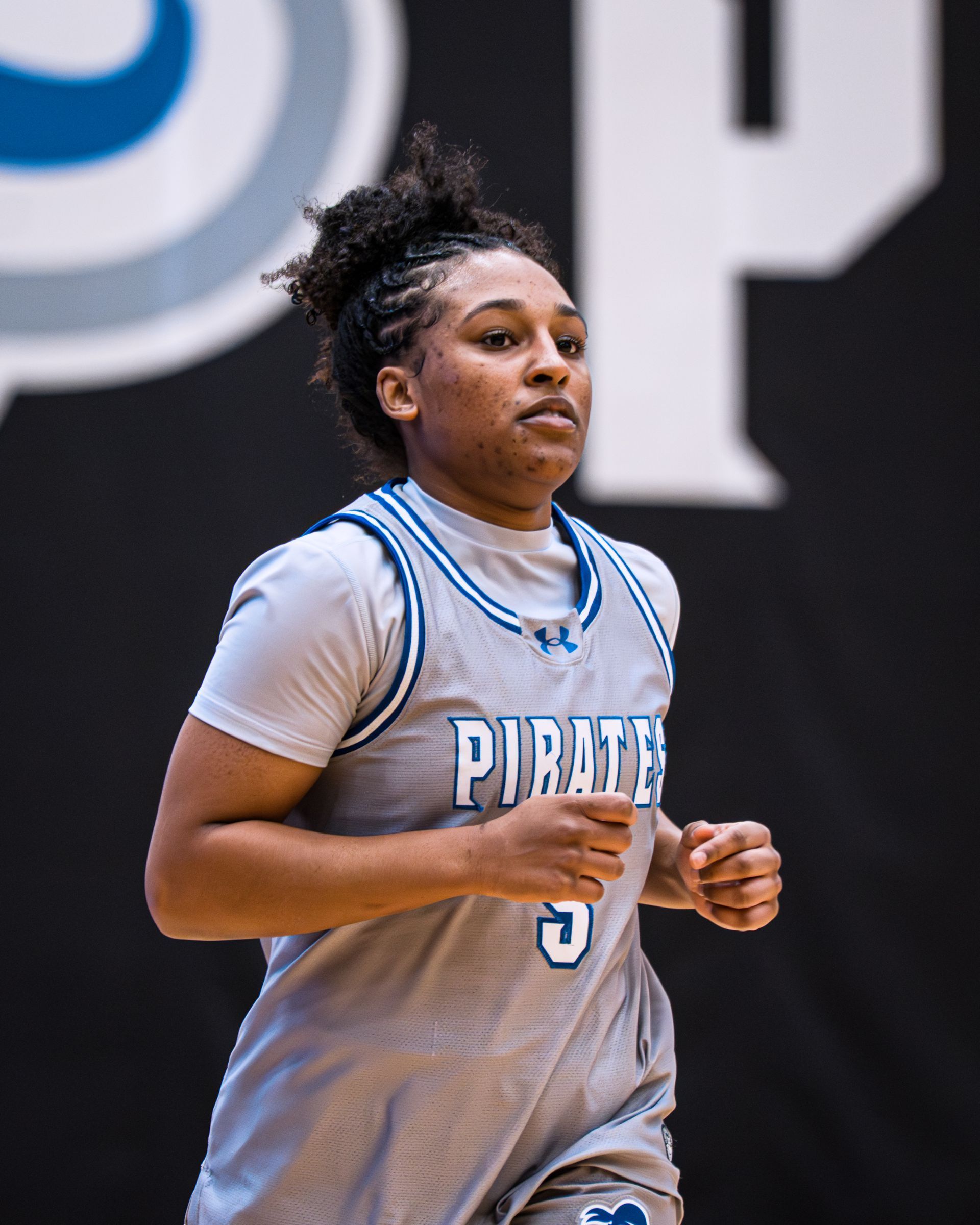 Basketball player in a gray Panthers jersey running on court during a game