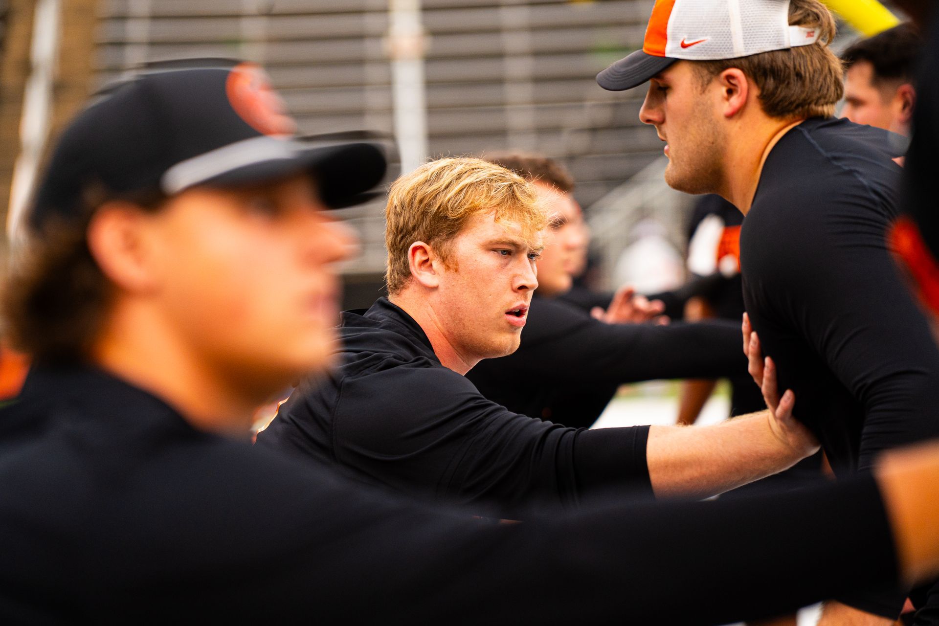 Two baseball players in black uniforms talking on the field, with a blurred player in the foreground.