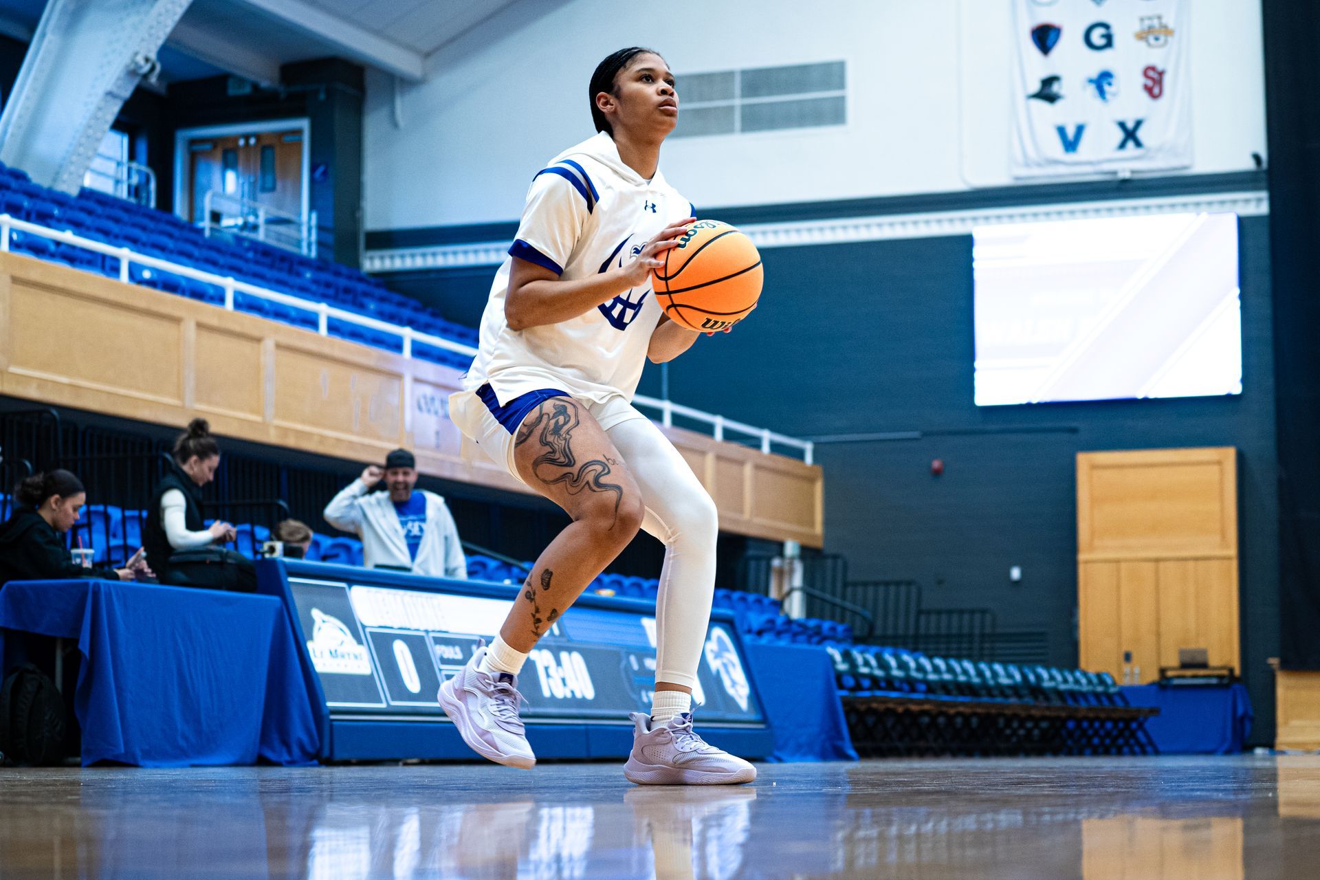 Basketball player in white jersey preparing to shoot on an indoor court
