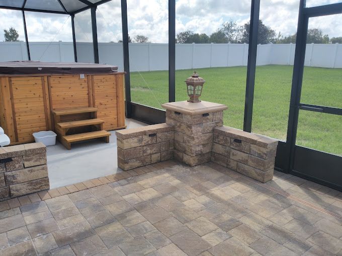 A screened in porch with a hot tub and steps leading to it.