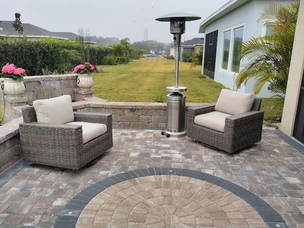 A patio with two chairs and a heater in the middle