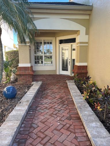 A brick walkway leading to the front door of a building.