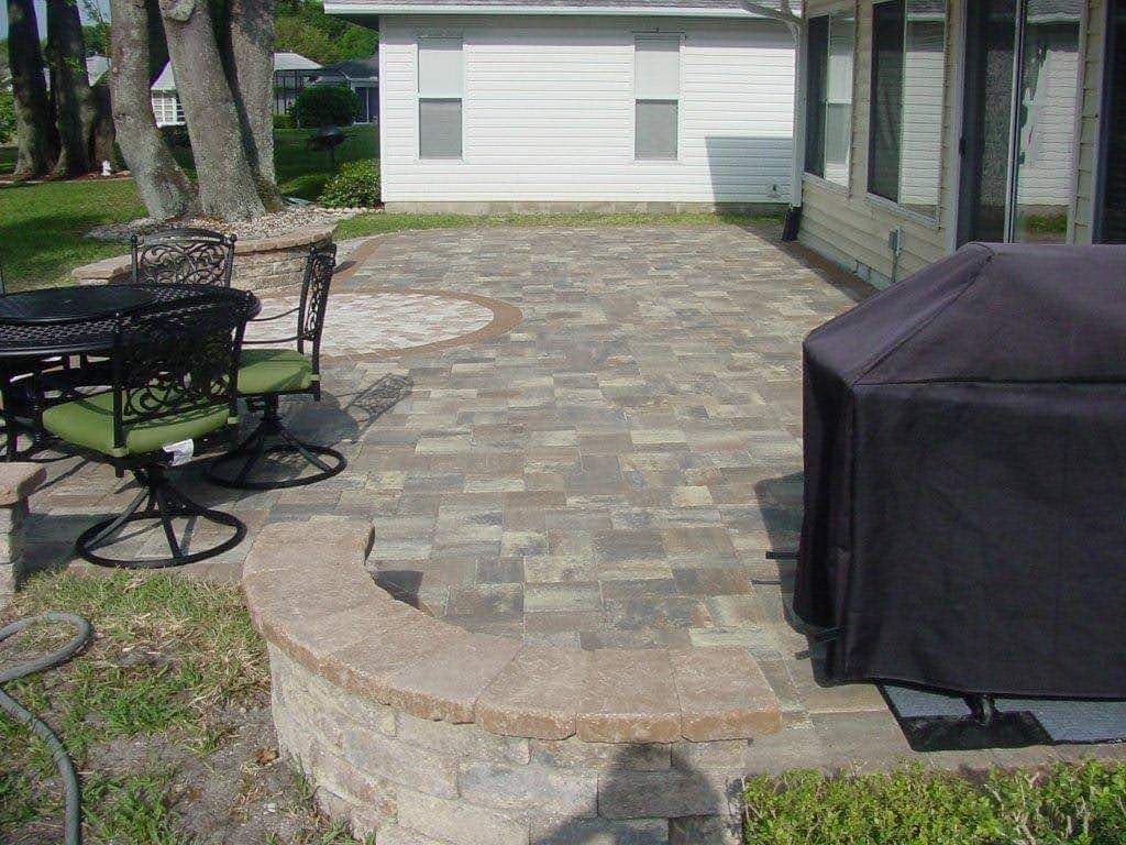 A patio with a table and chairs and a grill