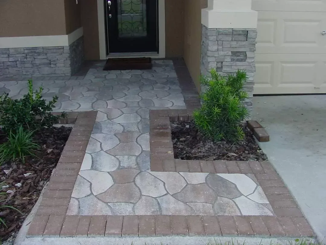 A brick walkway leading to the front door of a house