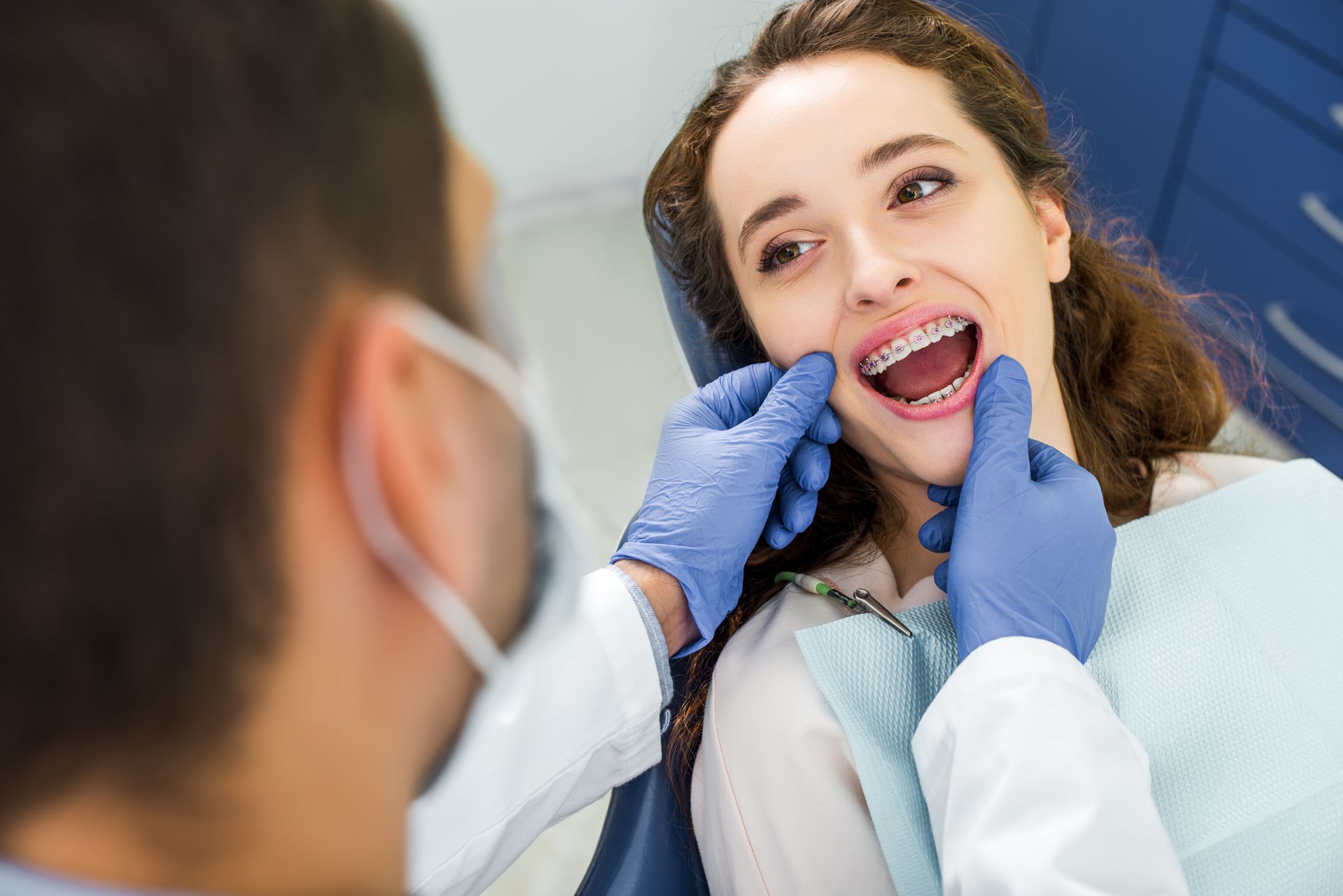 A dentist is examining a woman’s braces. A dentist is examining a woman’s braces.